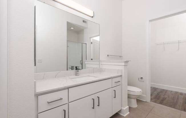 a bathroom with white cabinets and a white toilet