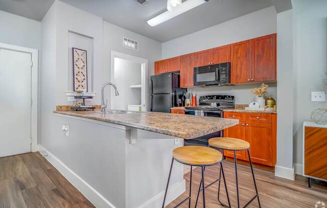 A kitchen with a granite countertop and wooden cabinets.