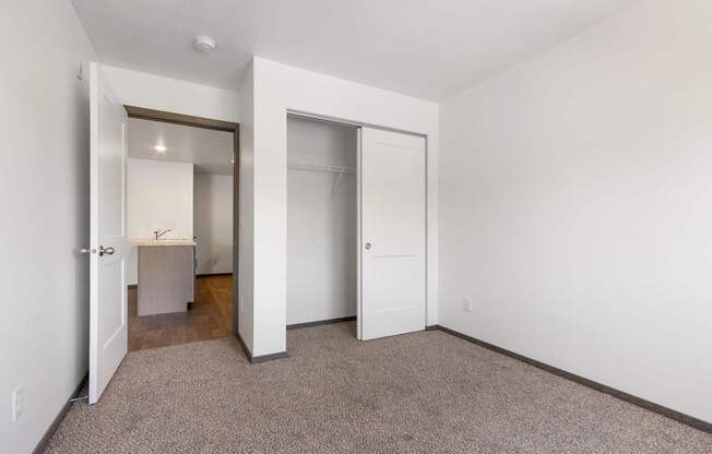 A room with a carpeted floor and a white door.