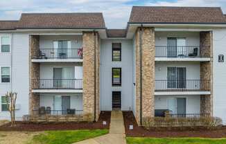 a picture of an apartment building with white siding and a brown roof