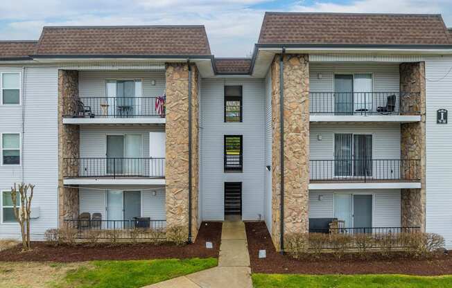 a picture of an apartment building with white siding and a brown roof