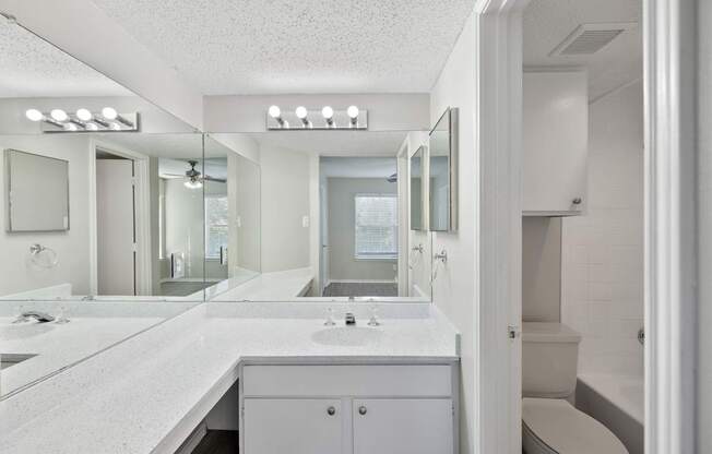 A white bathroom with a vanity and a toilet.