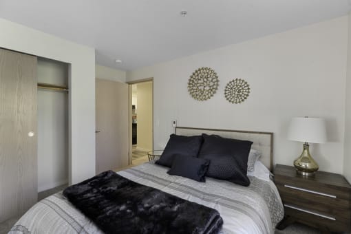 a bedroom with a bed and two mirrors on the wall  at Camelot Apartment Homes, Washington, 98204