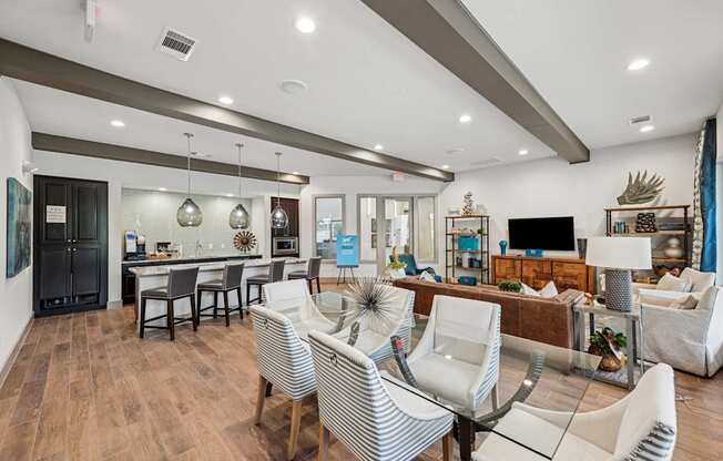A modern living room with a dining area and a kitchen in the background.