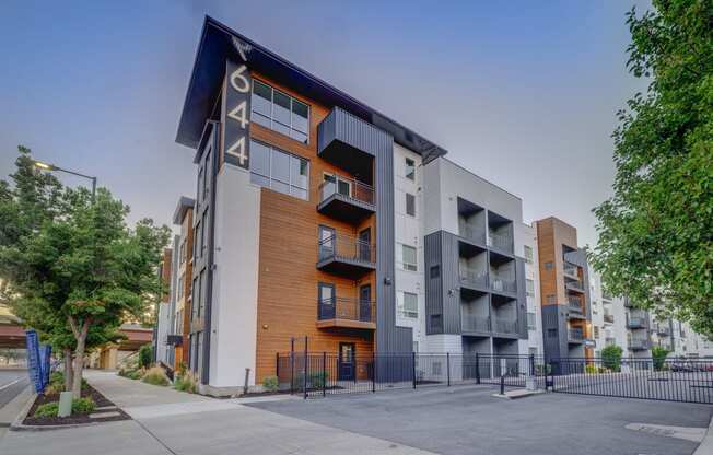 modern apartment building with a sidewalk in front of it