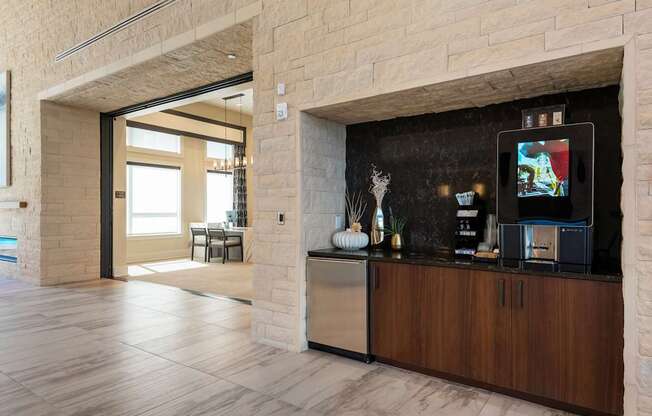 A modern kitchen with a wooden cabinet and a television on the counter.