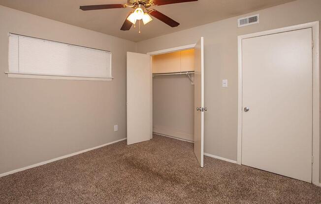carpeted bedroom with open closet doors
