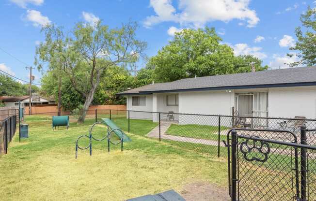 a backyard with a play area and a house in the background
