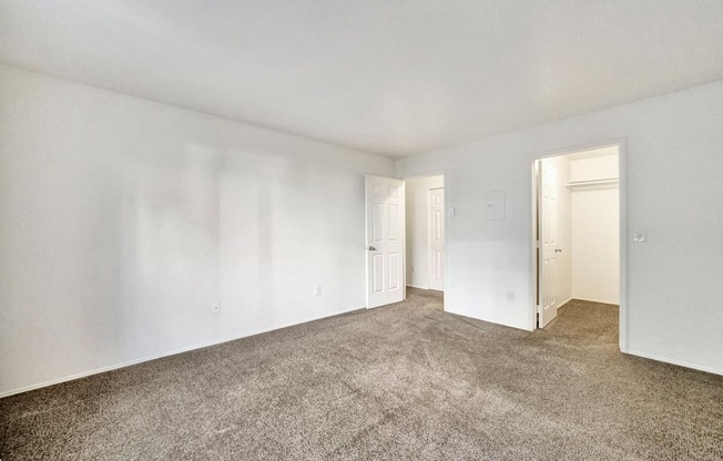 an empty living room with carpet and white walls