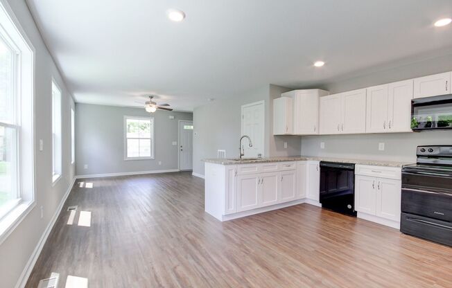 Two Story Duplex With Hardwood Flooring and White Cabinetry