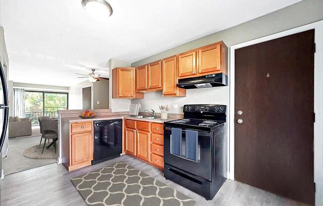 A modern kitchen with wooden cabinets and black appliances.