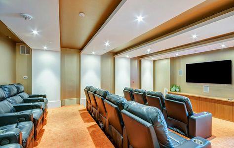 a large screening room with leather chairs and a tv