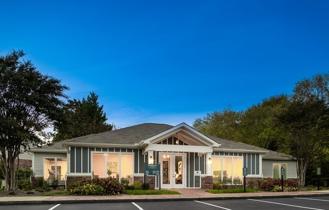 A house with a grey roof and a parking lot in front.