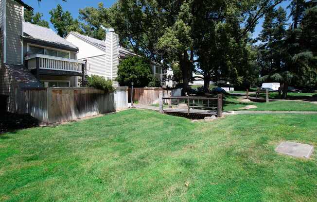 A backyard with a wooden fence and a green lawn.