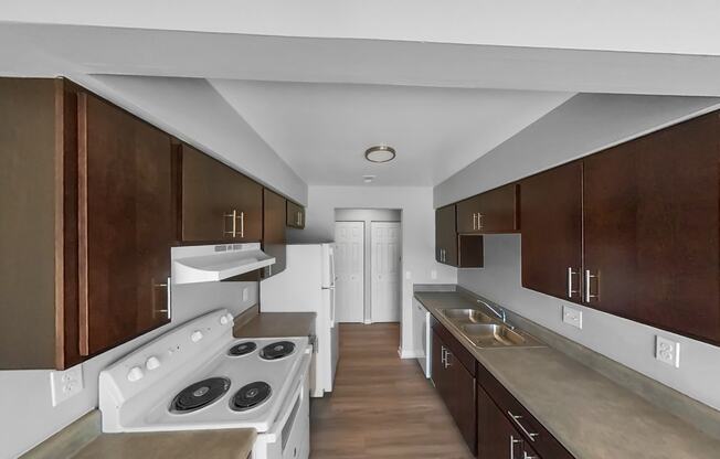 a kitchen with wooden cabinets and white appliances and a white stove