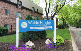 a sign for waldo heights in front of a brick building