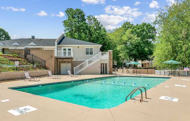 A swimming pool in a residential area with a house in the background.