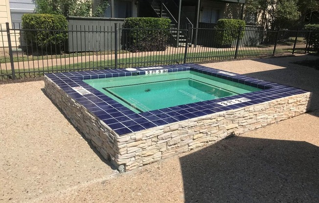 A small pool surrounded by a stone wall.