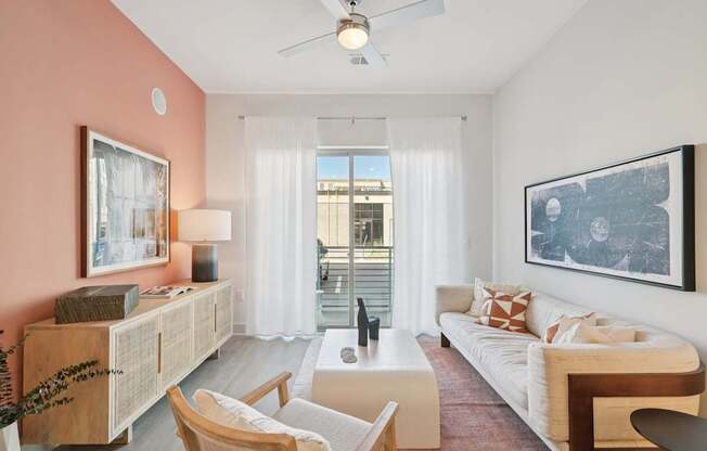 A living room with a white couch, a wooden coffee table, and a ceiling fan.