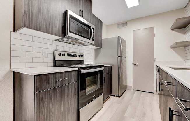 A modern kitchen with a stove top oven and microwave above it.