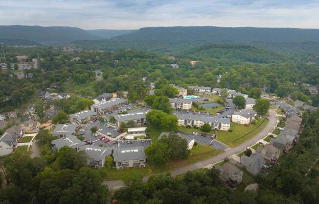 arial view of a neighborhood with trees and mountains in the background