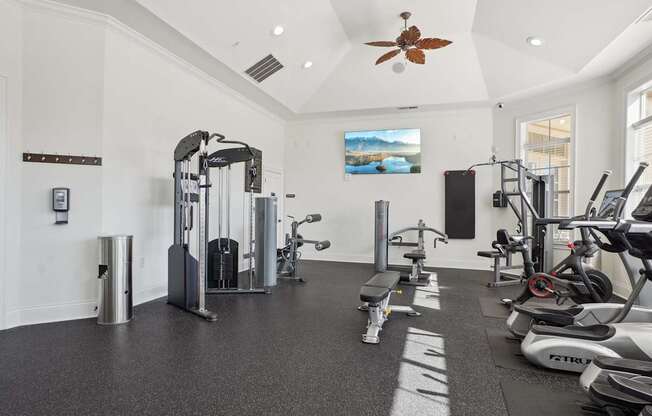 A spacious gym with a variety of equipment including treadmills, stationary bikes, and weight machines.