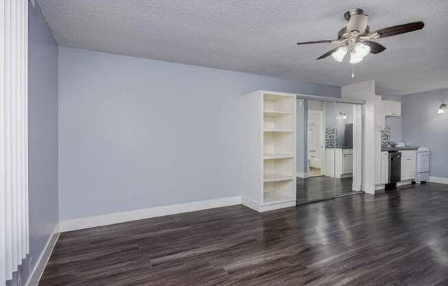 A room with a ceiling fan and a cabinet.