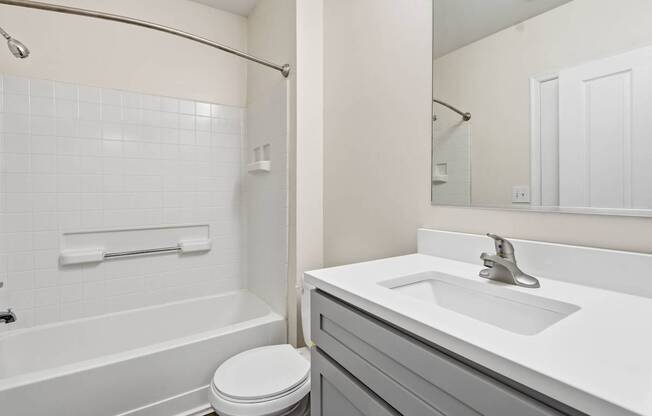 A white bathroom with a toilet, sink, and bathtub.