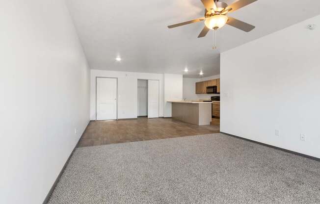 A room with a ceiling fan and carpeted floor.