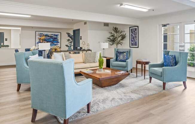 a living room with blue chairs and a couch and a coffee table