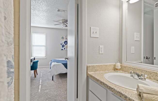 A bathroom with a blue bed in the background.