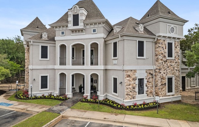 A large, two-story house with a stone facade and a grey roof.