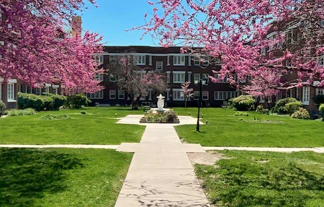 A pathway leads through a grassy area with a building in the background.