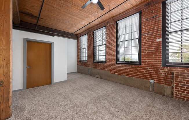 the interior of an empty room with brick walls and a door