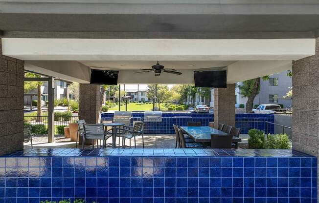 covered patio with grilling area and al fresco dining at Avora apartments