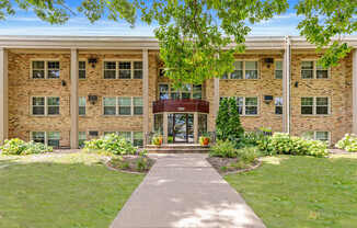 A building with a red awning and a walkway leading to it.