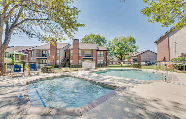 A swimming pool surrounded by a fence and trees.