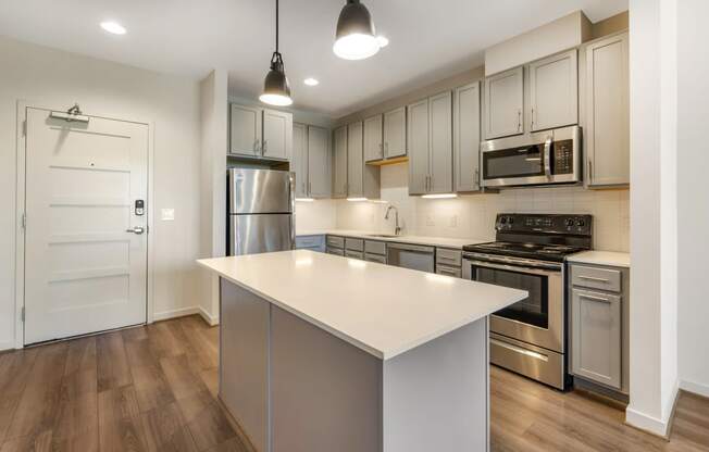 a renovated kitchen with a white island and stainless steel appliances