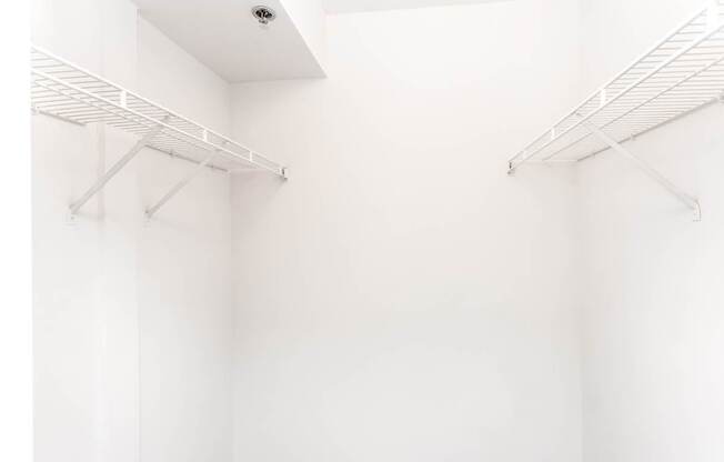 A white closet with two shelves.