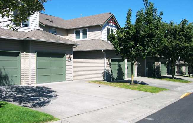 A row of houses with green garage doors.