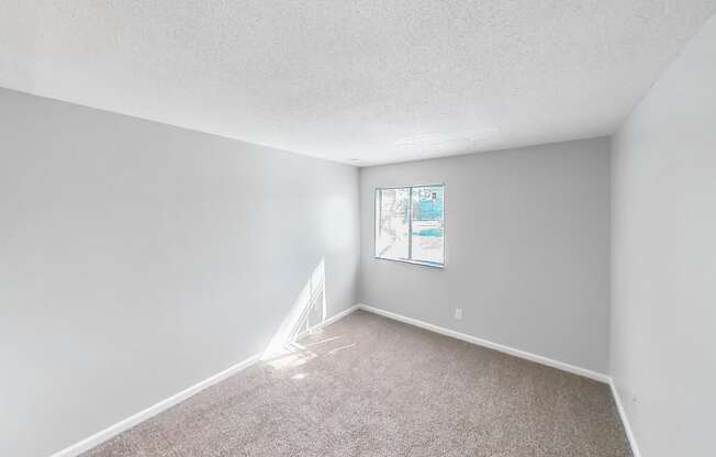 an empty room with white walls and a window