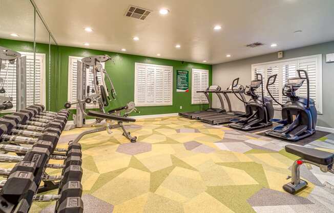 a gym with cardio machines and weights on the floor