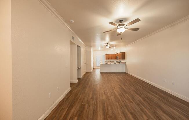 A long hallway with a ceiling fan and lighting.