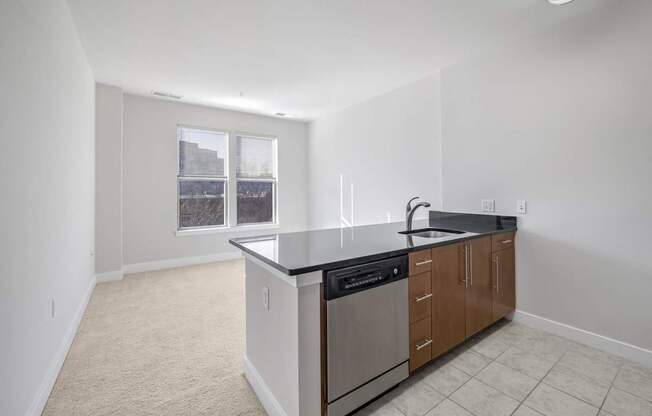 A kitchen with a black counter top and stainless steel appliances.