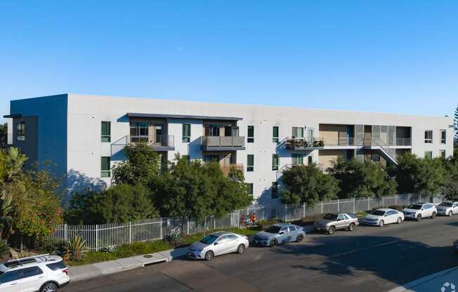 a white and blue building with cars parked in front of it