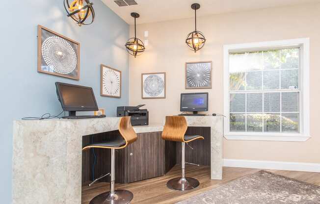 an office with two chairs and a desk with a window