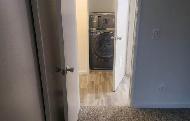 A white door is open to a room with a washer and dryer.
