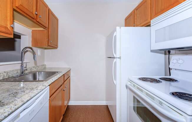 a kitchen with white appliances and wooden cabinets