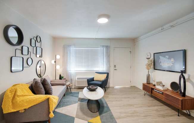 a living room with a couch and a tv at Presidio Palms Apartments, Arizona , 85701