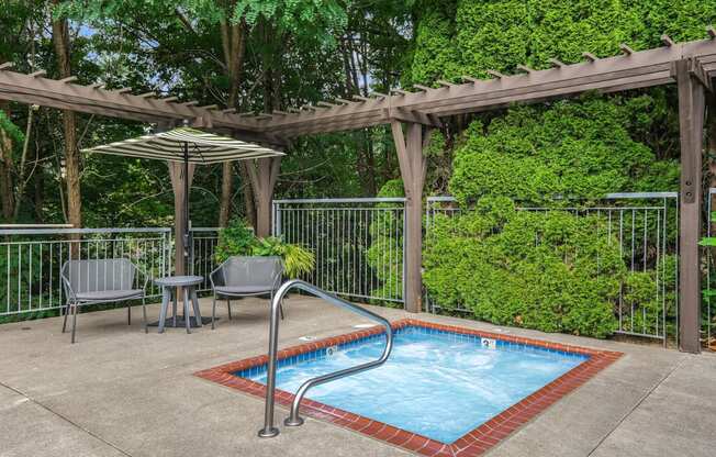 A small pool surrounded by a fence and a pergola.